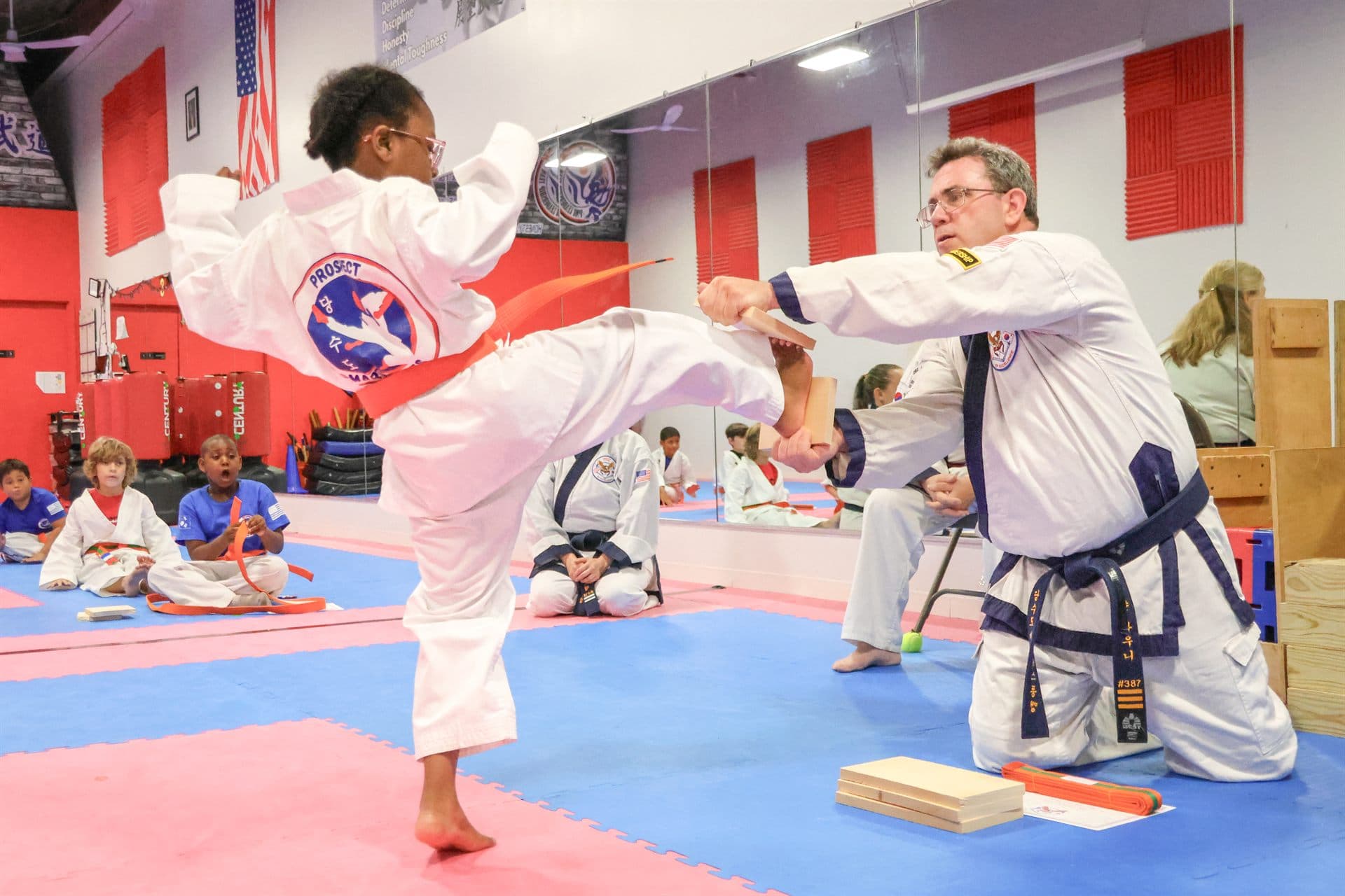 Student breaking a board with a side kick