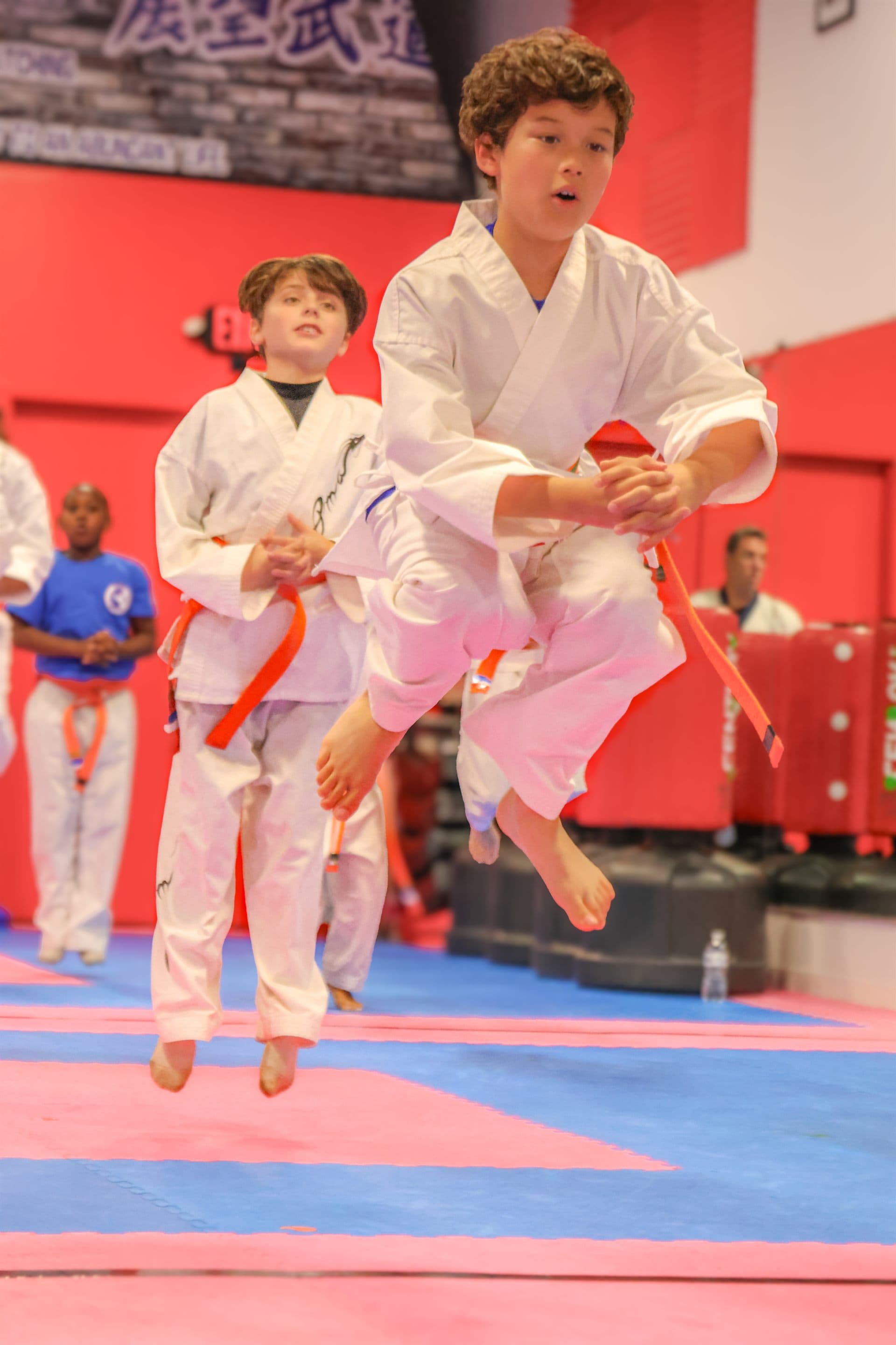 Two students mid-jump during class at Prospect Martial Arts